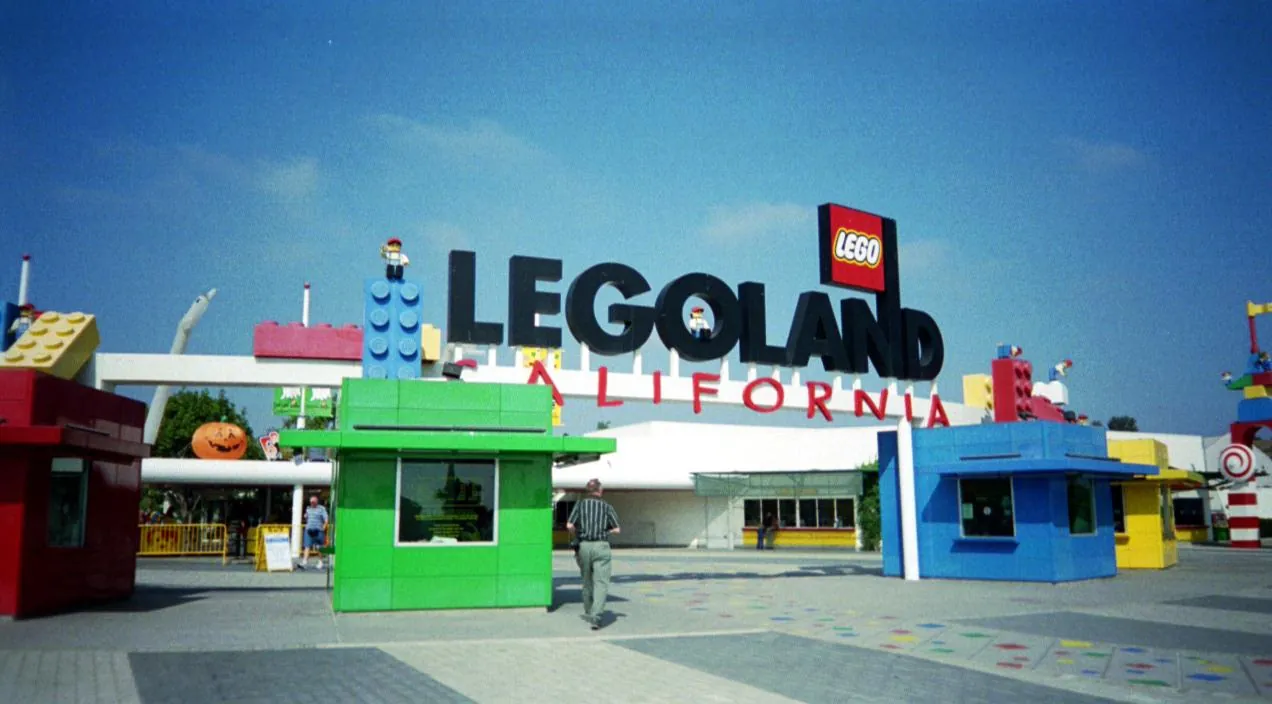The LEGOLAND California entrance sign, with giant LEGO bricks and colourful ticket booths in front of it