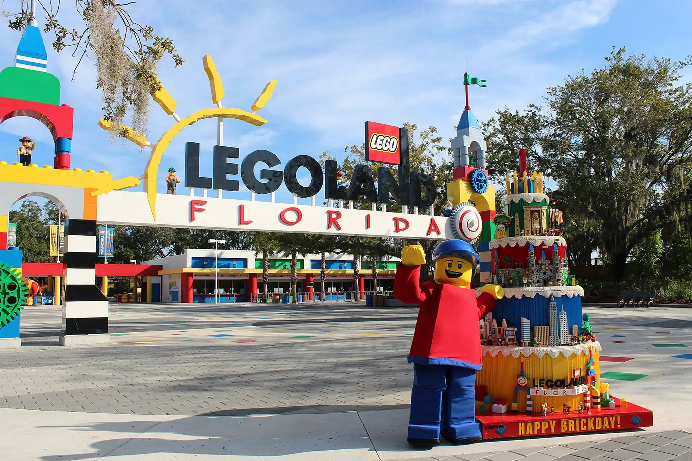 The LEGOLAND Florida entrance arch with a giant LEGO figure and a LEGO birthday cake in front of it